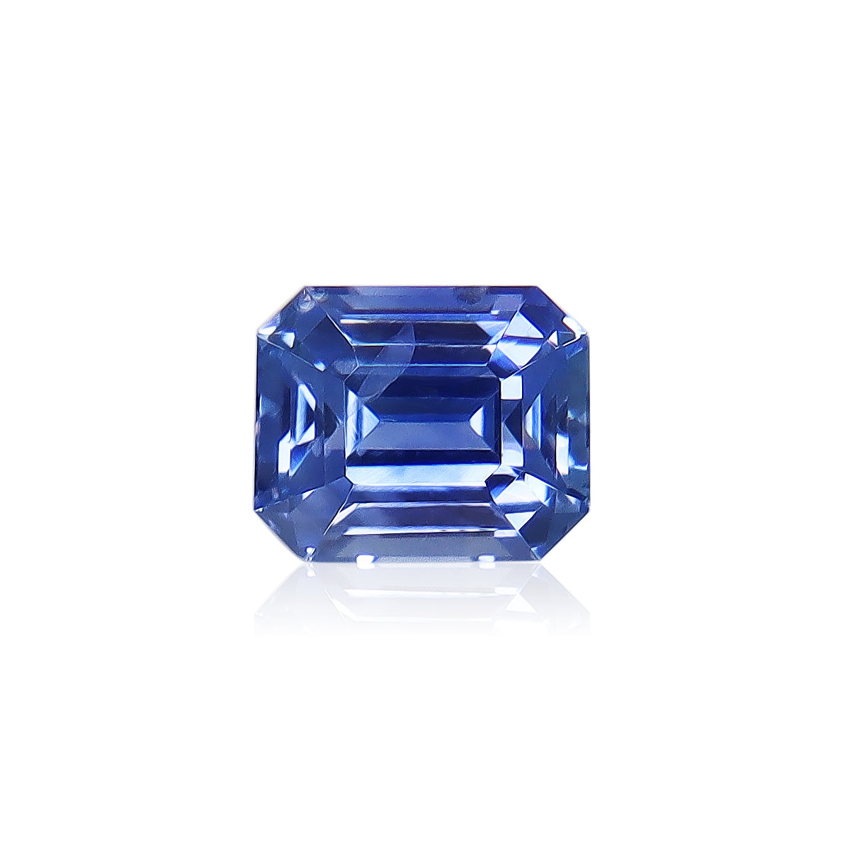 Le Saphir Bleu de 1,61 carat de Bonnot Paris présente une taille émeraude rectangulaire à facettes étagées, sublimant sa surface réfléchissante. Présenté sur un fond blanc, il met en valeur la clarté et la couleur vibrante de son origine sri-lankaise.