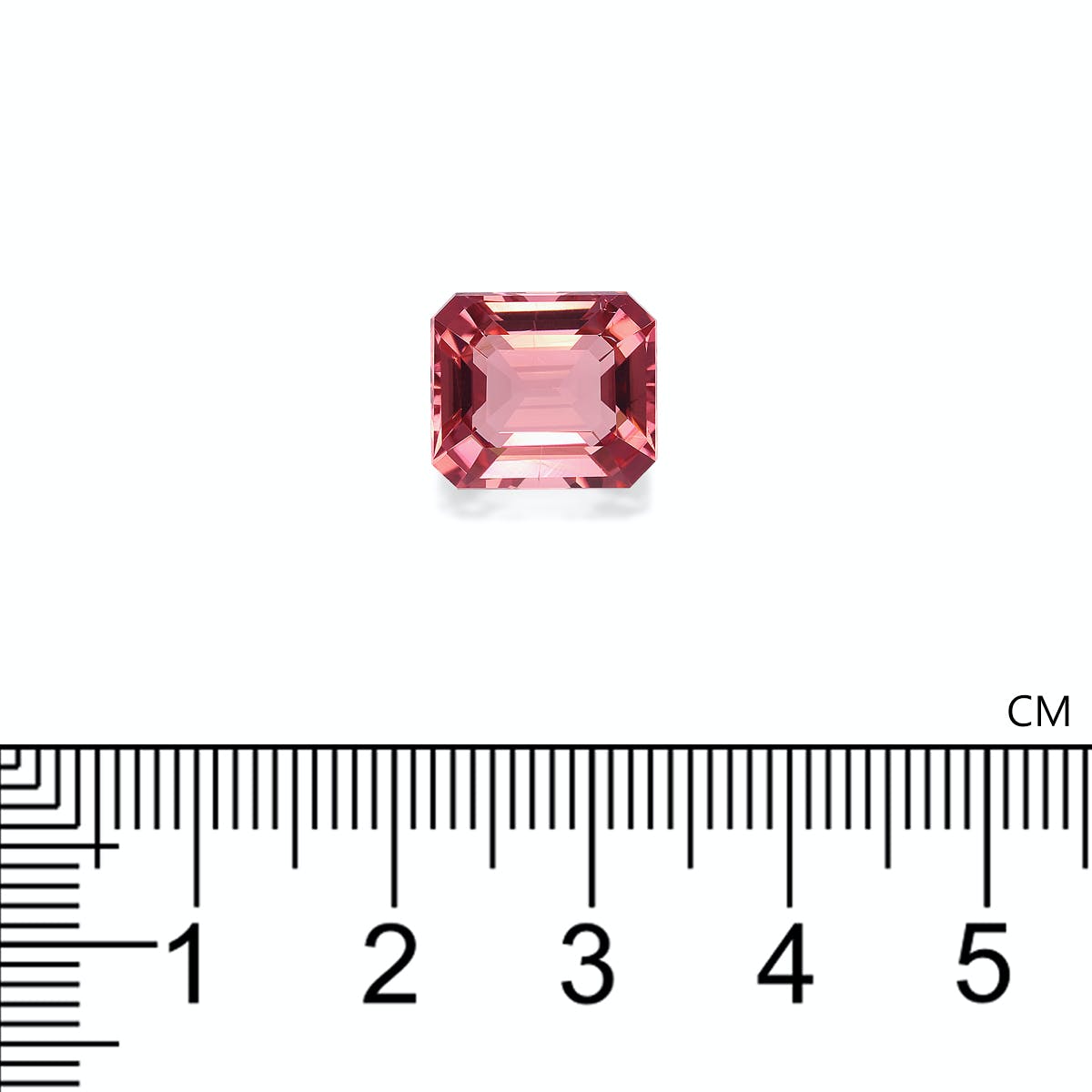 Une tourmaline rose rectangulaire de Bonnot Paris, pesant 6,53 carats et aux bords biseautés, est posée sur une surface blanche. Une règle en dessous indique sa taille : elle mesure un peu plus d'1 cm de large.