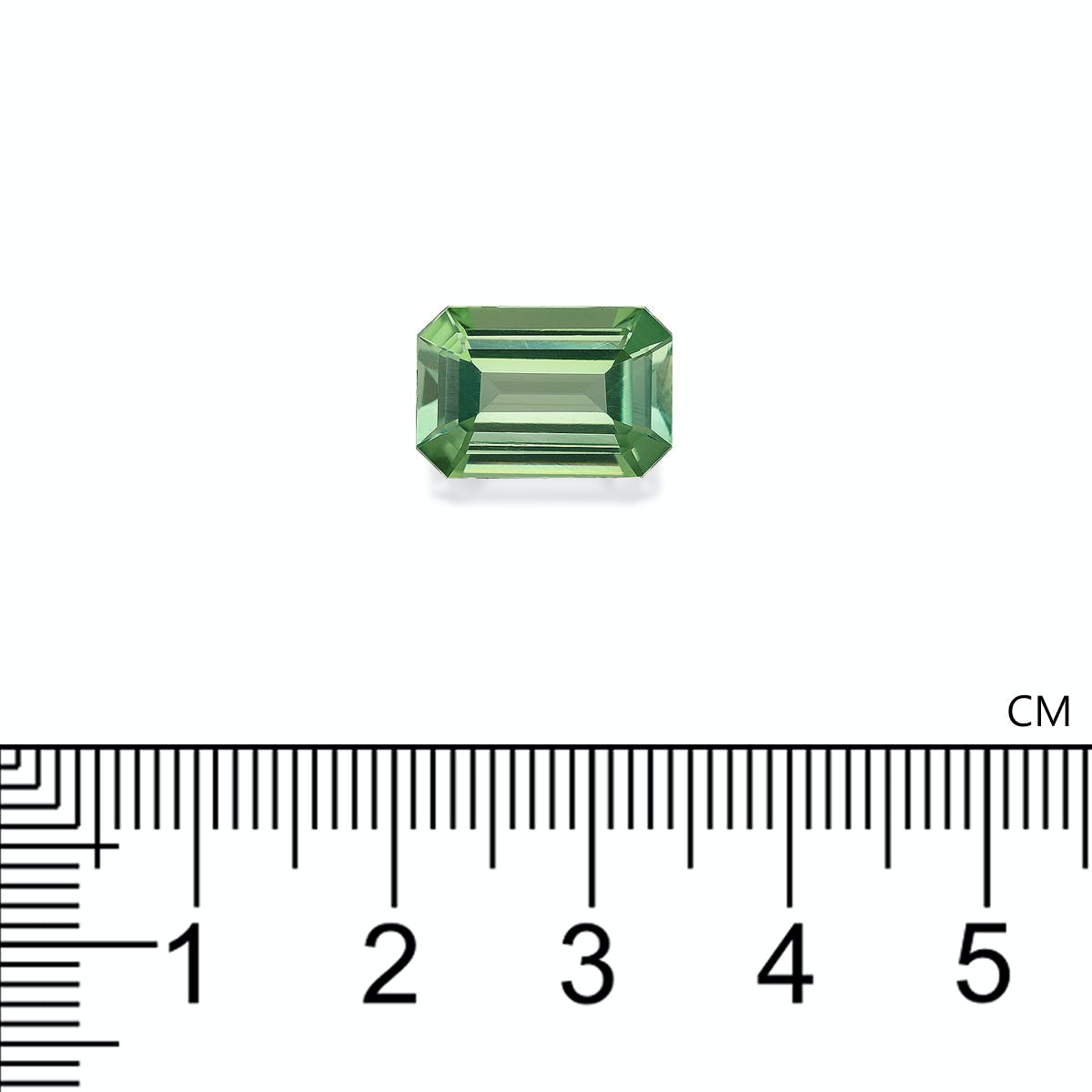 La Tourmaline Verte Bonnot Paris, une pierre précieuse verte rectangulaire de 4,82 ct avec une taille émeraude, est représentée sur un fond blanc à côté d'une règle indiquant sa longueur d'environ 1,5 centimètre.