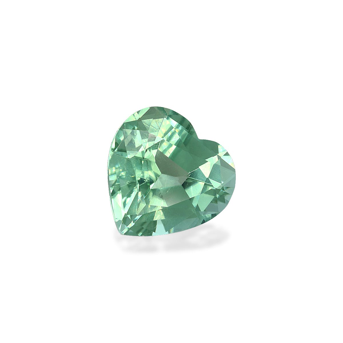 La Tourmaline Verte · 5,65 carats de Bonnot Paris est une pierre précieuse verte en forme de cœur aux facettes étincelantes, sertie sur un fond blanc. Son aspect riche et translucide présente différentes nuances de vert qui projettent une ombre douce.