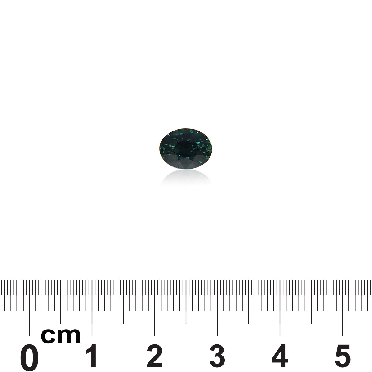Un Saphir Teal de 2,04 carats de Bonnot Paris, une petite pierre ovale foncée de Madagascar, est placé sur un fond blanc au-dessus d'une règle. La pierre élégante, légèrement réfléchissante, est centrée sur l'image, mettant en valeur sa taille par rapport à l'échelle centimétrique de la règle.