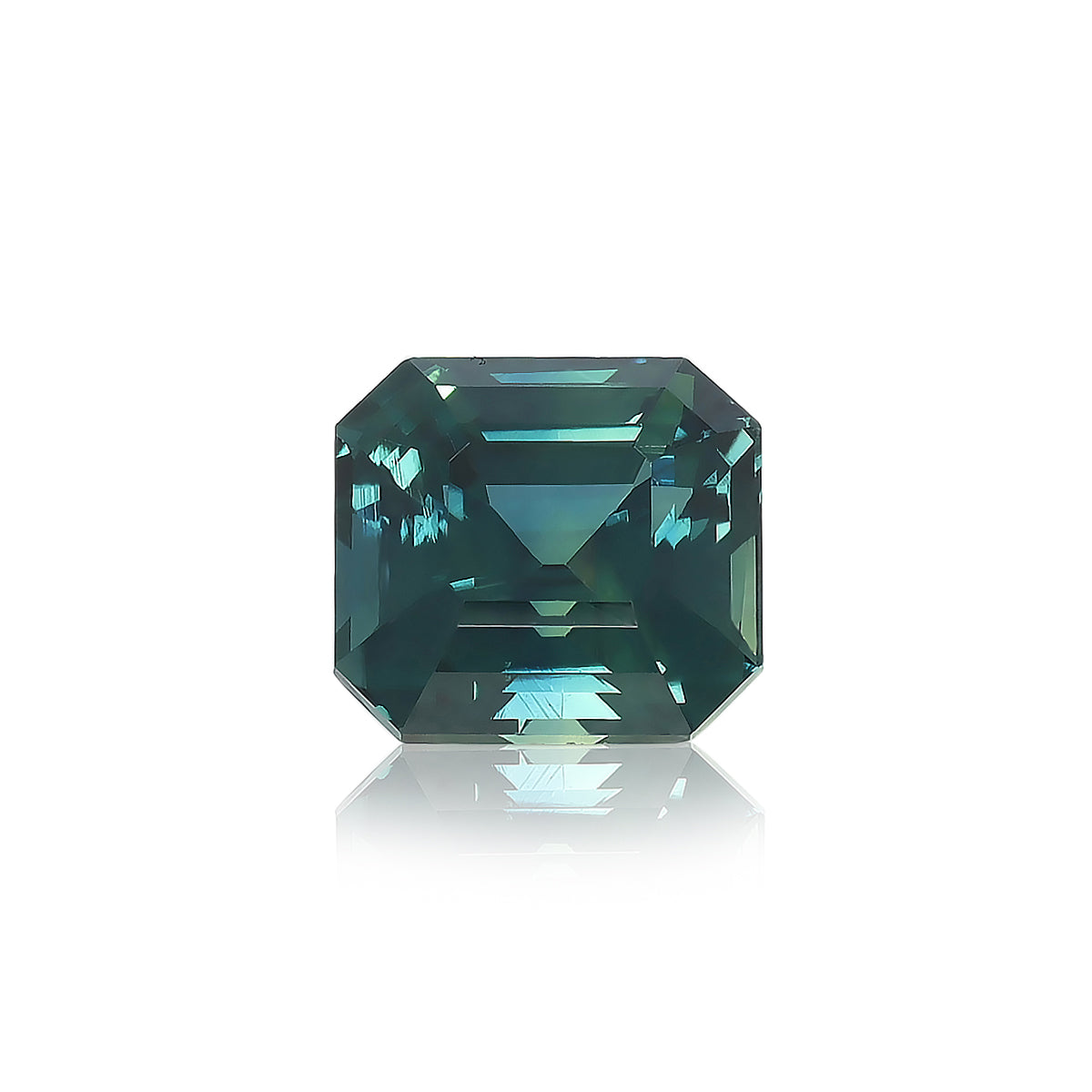 Un diamant taille carrée « Saphir Teal · 3,03 ct » de Bonnot Paris, d'une couleur bleu sarcelle profonde avec des bords biseautés et des facettes réfléchissantes, repose sur une surface blanche projetant une ombre subtile.