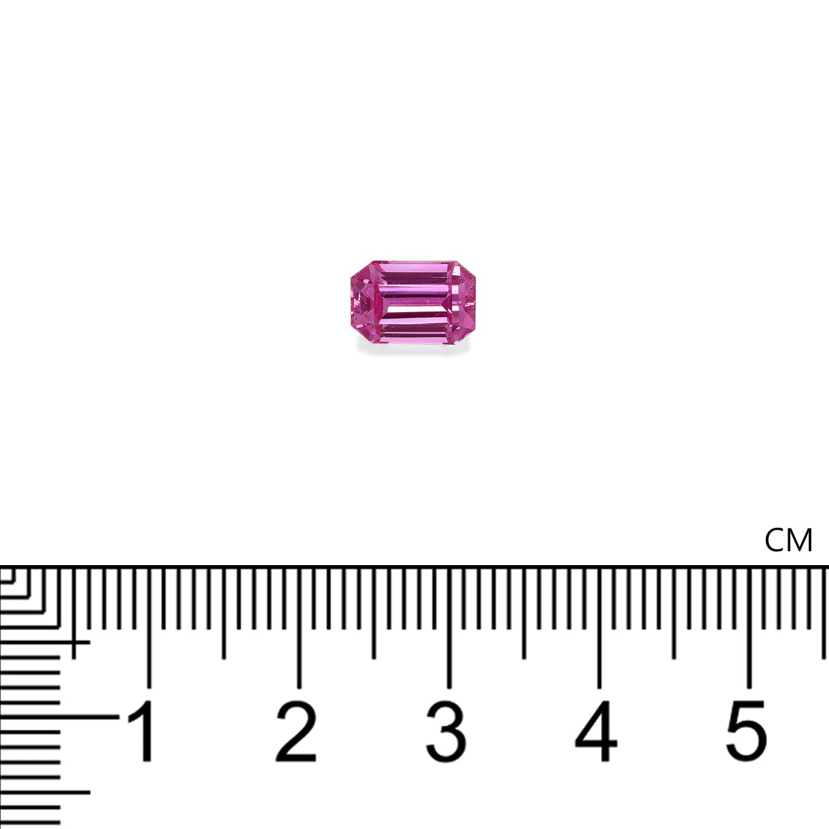 La petite pierre précieuse rectangulaire Saphir Rose de Bonnot Paris repose sur une surface blanche au-dessus d'une règle métrique, mesurant un peu plus de 0,5 cm de longueur.