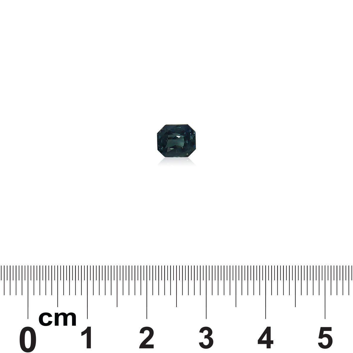 Le Saphir Teal, une pierre précieuse taille émeraude de 1,6 ct de Bonnot Paris en vert foncé, est sertie sur un fond blanc avec une règle centimétrique en dessous pour l'échelle.