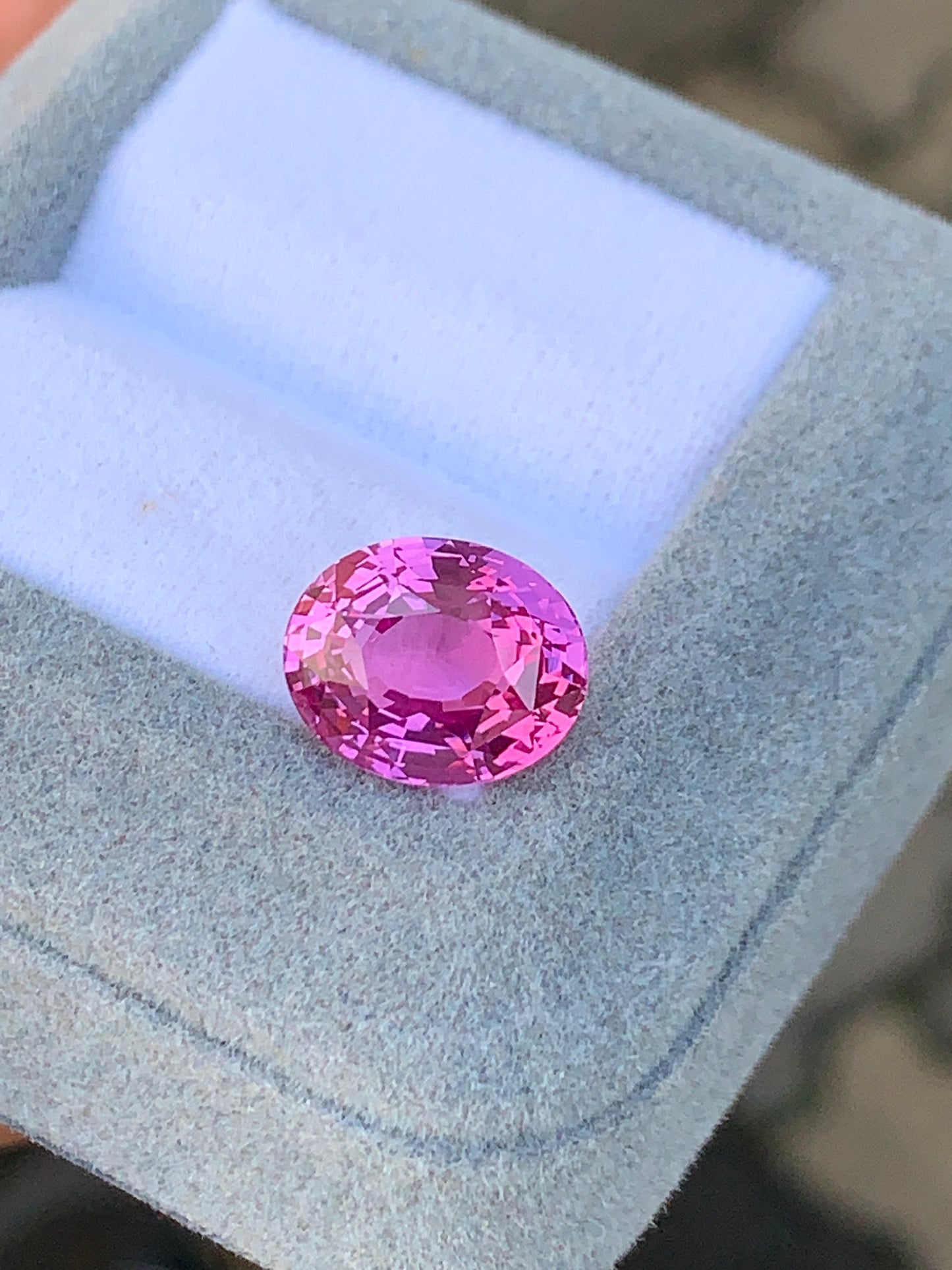 Un Saphir Rose rond facetté • 7,05ct scintille élégamment sur un fond de tissu bleu-gris doux et clair à l'intérieur d'un [NOUVEAU] coffret à bijoux Bonnot Paris.