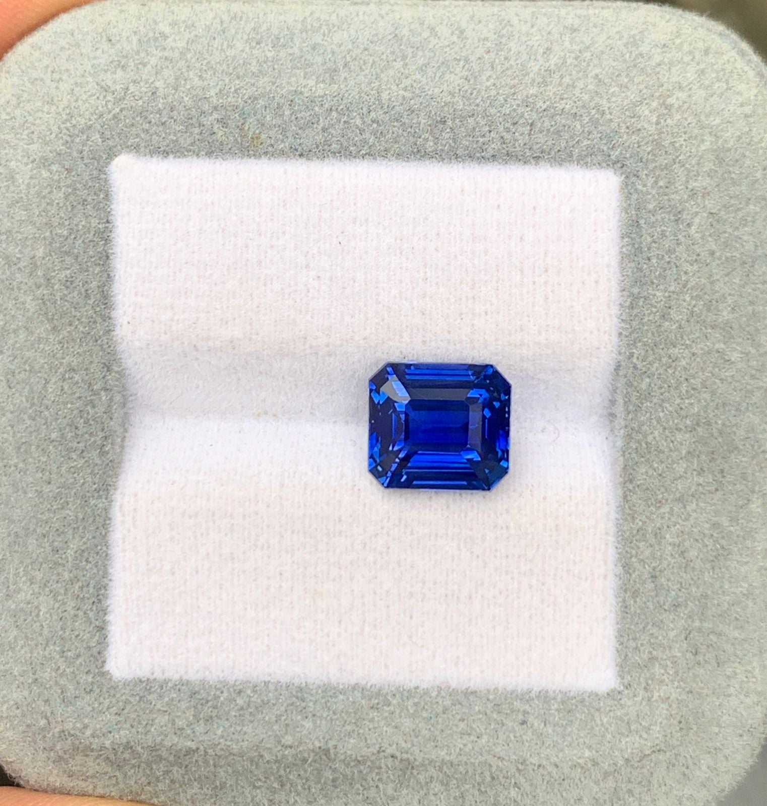Un superbe saphir rectangulaire taille émeraude de 4,05 carats signé Bonnot Paris repose gracieusement sur un écrin gris clair et blanc. Ce saphir bleu naturel du Sri Lanka arbore une teinte bleu profond et limpide, empreinte d'une élégance intemporelle.