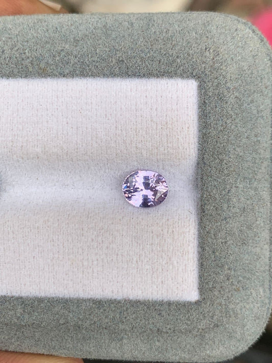 Un Saphir Lavande violet pâle rond de 1,20 ct du Sri Lanka est élégamment présenté sur un support à bijoux gris et blanc doux de Bonnot Paris, savamment facetté pour un éclat exquis parfait pour la haute joaillerie.