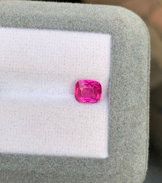 Un saphir rose de 1,52 carat de la collection Bonnot Paris, taillé en forme carrée, scintille sur un fond blanc matelassé bordé d'un liseré gris clair. Originaire du Mozambique, cette gemme naturelle reflète magnifiquement la lumière sur ses facettes exquises.