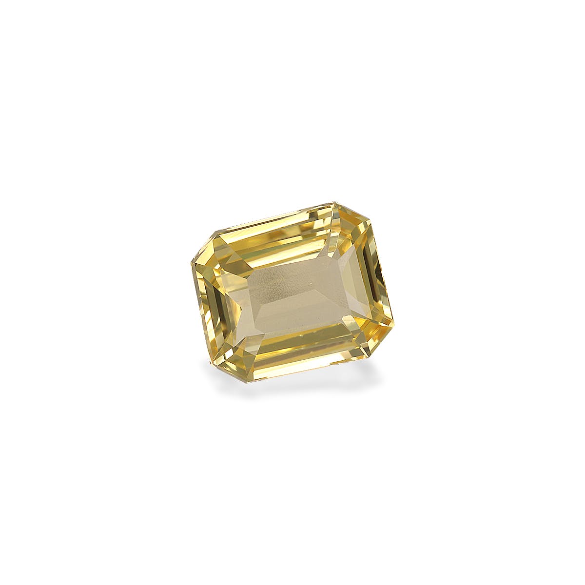 Le Saphir Jaune · 2,05 carats de Bonnot Paris est une pierre précieuse taille émeraude jaune étincelante qui reflète magnifiquement la lumière. Sa forme rectangulaire aux bords biseautés et aux facettes transparentes se détache sur un fond blanc uni.