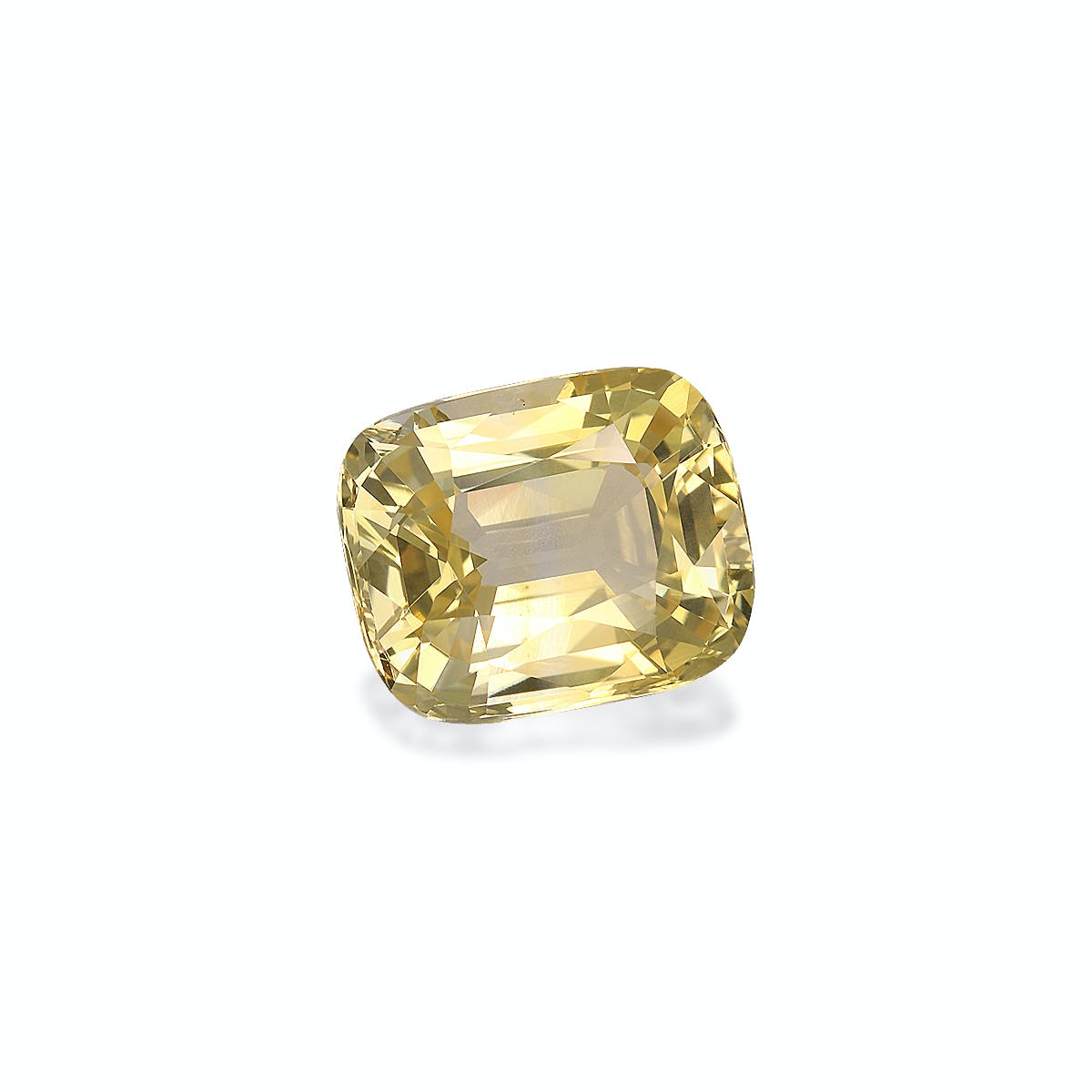 Le Saphir Jaune de Bonnot Paris, une pierre précieuse jaune pâle taille coussin pesant 5,58 ct, présente des facettes complexes et est présentée sur un fond blanc avec une ombre subtile.
