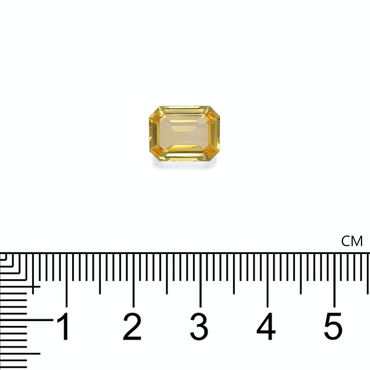 Une pierre précieuse jaune rectangulaire de Bonnot Paris, rappelant un saphir rectangulaire non chauffé, est placée au-dessus d'une règle et mesure un peu plus d'1 cm de large. Ce Saphir Jaune de 4,04 carats présente une exquise taille émeraude aux bords biseautés.